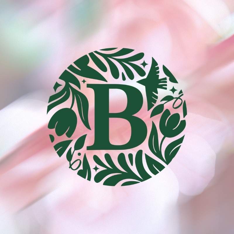 Green floral wreath with a letter 'B' in the center on a blurred background