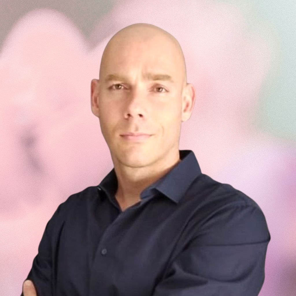 Man wearing a dark blue shirt against a pink and purple gradient background