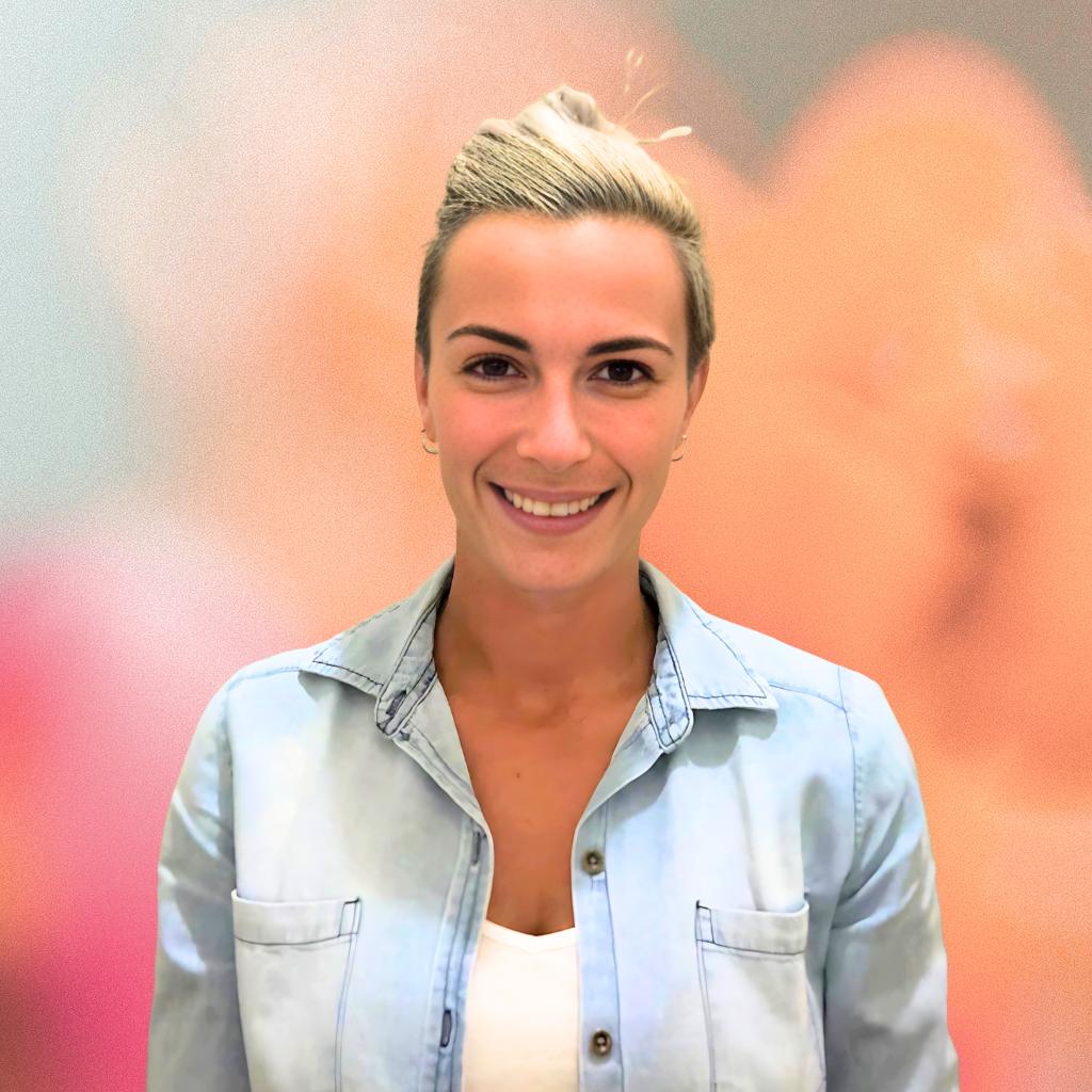 Woman wearing a light blue denim jacket against a blurred background