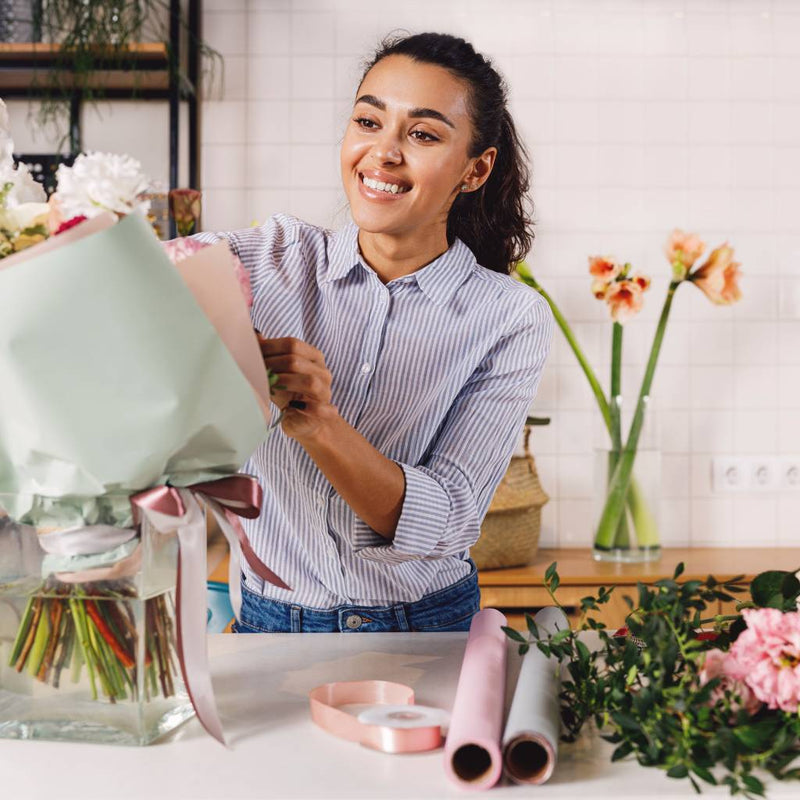 Florist arranging a bouquet of fresh flowers in her studio